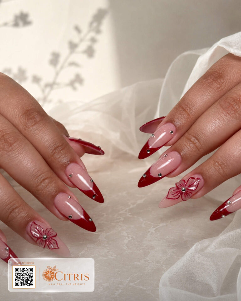 Ruby French nail extensions with hand-painted floral accents by Citris Nail Spa